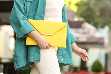 Young woman with elegant envelope bag outdoors on summer day, closeup - obrazy, fototapety, plakaty
