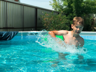 A 9-year-old boy plays in the frame pool at the cottage. Games in the pool