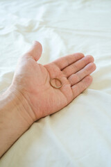 Hand of a man holding a wedding ring