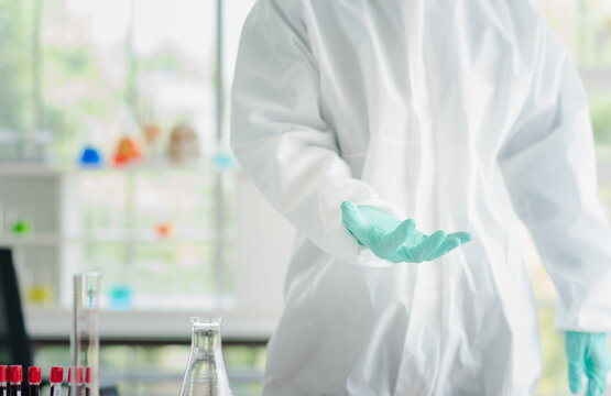 Scientist Man In White Sterilize Lab Coat Standing And Raise Empty Hand Copy Space To Add Concept Idea In Laboratory Room