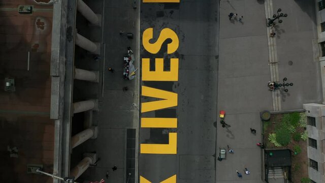 spinning and rising over BLM sign painted on Joralemon St. in downtown Brooklyn