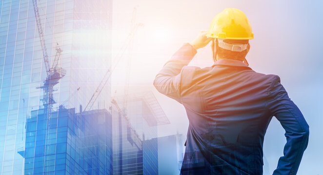 Double Exposure Of Building Under Construction And Man Engineer Turn Around Helmet Wearing A Suit Thinking Of Ways And Ideas For Building New Buildings In The Future.