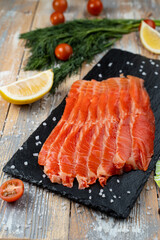 Close up of red trout slices on a dark stone background, appetizing photo for a market catalogue