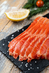 Close up of red trout slices on a dark stone background, appetizing photo for a market catalogue
