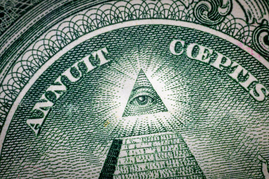All-seeing eye on US one dollar bill closeup macro with soft focus on a pyramid.