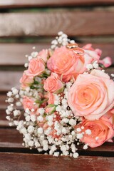 Romantic pink rose bouquet on a wooden branch outside, close up