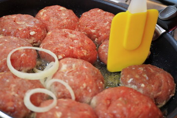 Cooking chops in a frying pan.