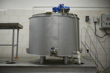 Process of making dairy products. Milk pasteurization machine. Mixing of dairy products in a large cistern at a dairy factory. Modern equipment at dairy plant.