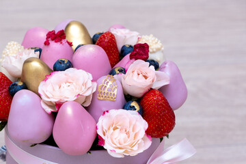 delicious bouquet of strawberries in white, pink and gold chocolate on a light background.