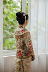 Beautiful Asian bride at the bright window