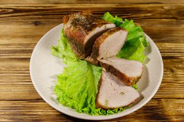 Tasty baked pork with spices on a wooden table