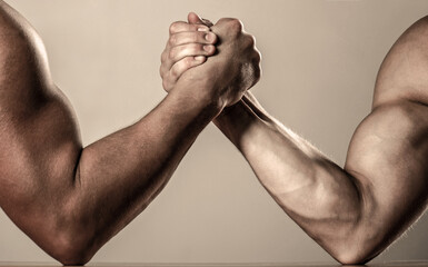 Muscular men measuring forces, arms. Hand wrestling, compete. Hands or arms of man. Muscular hand. Rivalry, closeup of male arm wrestling.
