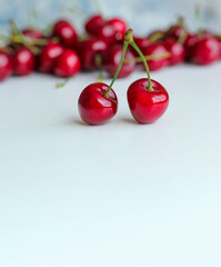 Two berries of red cherries on one petiole on a white background with place for text.