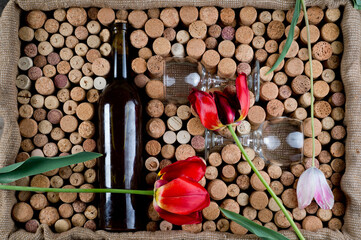 Wine corks of different sizes, a corkscrew, a bottle of wine and a glass shot on an old wooden...