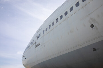 Close-up and high-view shot with beautiful blue sky background of airplane's head part which has been used for flight service for long time showing water stain and rust on the metal surface.