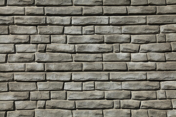 Brick wall texture, background in grey, faded color. Masonry-style concrete wall. Stylish fencing, made of decorative stone. Modern fashionable design for the fences