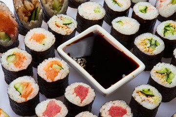 Various kinds of sushi roll set served on cutting board. Japanese food