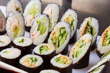 Various kinds of sushi roll set served on cutting board. Japanese food