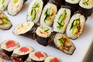 Various kinds of sushi roll set served on cutting board. Japanese food
