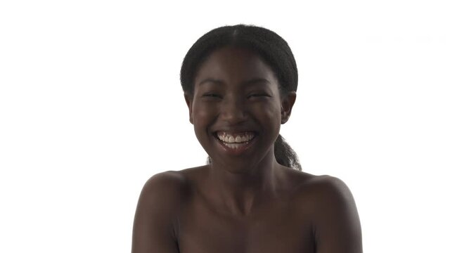 Portrait of young African woman laughing on white background