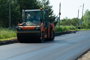 The large working machine of the skating rink makes a new asphalt. Road repair. Close-up