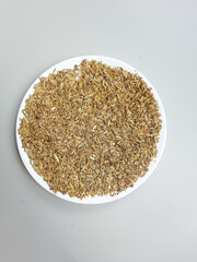 Greenish dried granules of Aniseed, or Pimpinella Anisum seed, or Adas Manis in Indonesia, on a plate