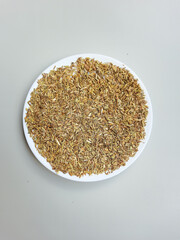 Greenish dried granules of Aniseed, or Pimpinella Anisum seed, or Adas Manis in Indonesia, on a plate