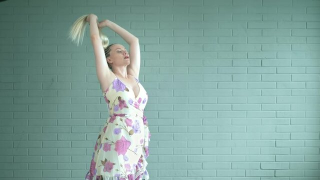 studio shot. woman with afro braids and a long ponytail against a brick wall