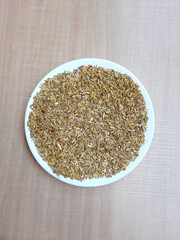 Greenish dried granules of Aniseed, or Pimpinella Anisum seed, or Adas Manis in Indonesia, on a plate