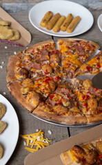 assortment of accessories and cut barbecue pizza on the restaurant table. Pizza shop. nuggets, chicken fingers