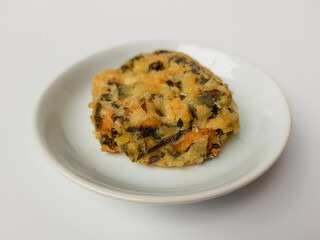 Rolade daun singkong, is a fried food from Indonesia. Made from cassava leaves, tofu and flour. Isolated in white background.