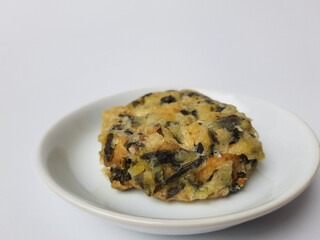 Rolade daun singkong, is a fried food from Indonesia. Made from cassava leaves, tofu and flour. Isolated in white background.