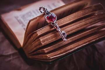 Open book with a beautiful metal key. The key to knowledge. Key with a red heart. Love for learning. - 361482388