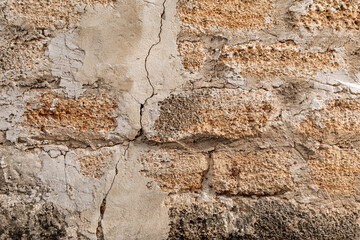 Rough texture of a brick wall made of shells. There is a crack in the middle of the wall