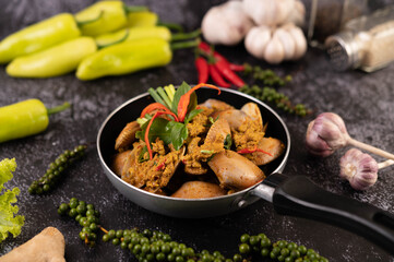 Curry powder stir-fried on a black pan with garlic Chili and basil.