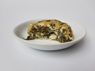 Rolade daun singkong, is a fried food from Indonesia. Made from cassava leaves, tofu and flour. Isolated in white background.