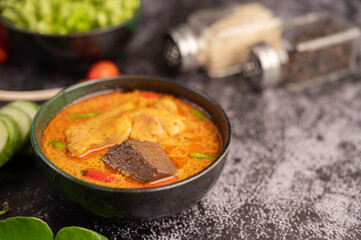 Chicken curry in a black cup.
