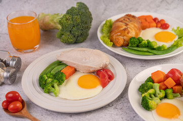 Breakfast consisting of bread, fried eggs, broccoli, carrots, tomatoes and lettuce on a white plate.