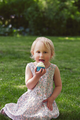 cute girl is eating cupcake in a park