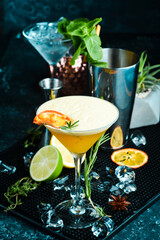 Alcoholic cocktail with sea buckthorn and orange with liqueur in a glass. On a black stone background. Menu bar.