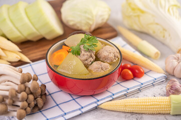 Pork ball soup in a cup on a blue-white cloth.