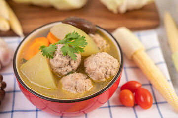 Pork ball soup in a cup on a blue-white cloth.