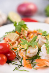 Spicy salad with shrimp on a white plate. Thai food.