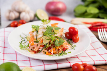 Spicy salad with shrimp on a white plate. Thai food.
