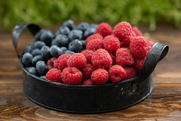fresh ripe blueberries and raspberries on a plate