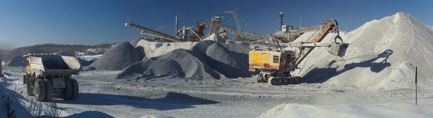 Panorama of stone crushing equipment in a mining enterprise with a mining excavator and heavy...