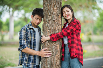 Men and women standing and hugging trees.