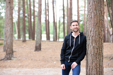 Portrait of a man lean against a tree looking casual