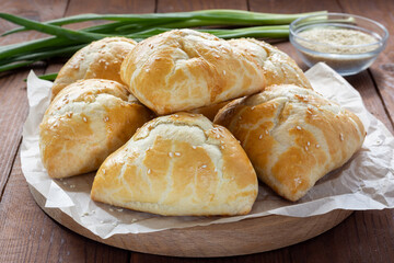 Delicious Uzbek samsa with meat and onions sprinkled with sesame on the table.