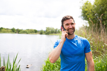 Naklejka na ściany i meble man on the phone by a lake